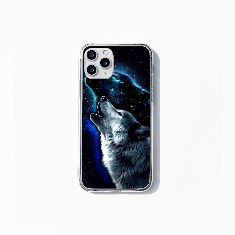 May include: Clear phone case with a howling wolf design. The wolf is rendered in grey and white against a backdrop of a starry night sky with blue and purple hues. The case has a clear border.