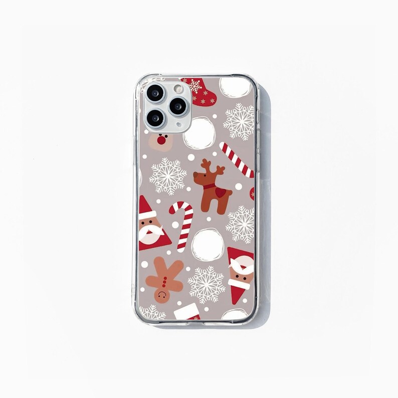 May include: A clear phone case with a Christmas-themed design. The case features a pattern of snowflakes, candy canes, reindeer, Santa Claus, and gingerbread men on a light gray background.