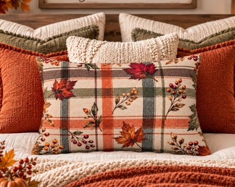 May include: A rectangular throw pillow featuring a cream-colored base with a plaid pattern in shades of orange, green, and brown. The pillow is decorated with a print of autumn maple leaves and clusters of red and orange berries across the surface.