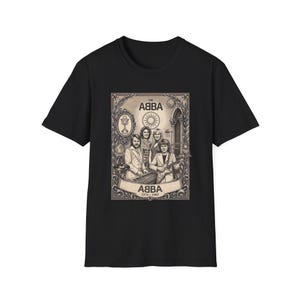 Könnte beinhalten: Ein schwarzes T-Shirt mit kurzen Ärmeln und einem zentralen Grafikdruck der Band ABBA. Das Design zeigt eine sepiafarbene Illustration der vier Mitglieder, ein Mikrofon, eine Sonne sowie den Text "THE ABBA" und "ABBA 1974-1982" in einem Rahmen.