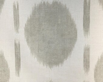 May include: Close-up of a fabric with a repeating pattern. The design features large, oval-shaped motifs in a muted gray color, set against a white background. Vertical stripes of gray accent the design, creating a textured appearance. The fabric has a linen-like texture.