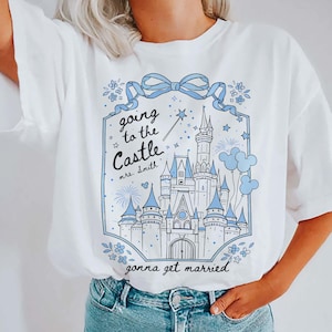 May include: White t-shirt featuring a blue and white castle graphic with the text "going to the Castle mrs. Smith gonna get married". The design includes a bow, stars, flowers, and a magic wand.