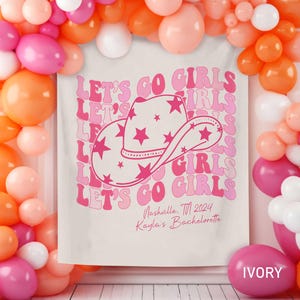 Puede incluir: Un tel&oacute;n de fondo blanco con texto rosa que dice "Let's Go Girls" repetido en una fuente retro. Un sombrero de vaquero rosa con estrellas blancas est&aacute; centrado en el tel&oacute;n de fondo. El texto "Nashville, TN 2024 Kayla's Bachelorette" est&aacute; impreso debajo del sombrero.