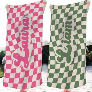 May include: Two beach towels with a checkered pattern in pink and white and green and white. The towels have a name written on them in a retro font. The names are "Laura" and "Liam".