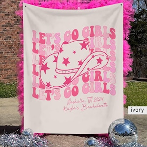 Puede incluir: Una pancarta blanca con texto rosa que dice "Let's Go Girls" con un sombrero de vaquero rosa con estrellas. La pancarta tambi&eacute;n incluye el texto "Nashville, TN 2024 Kayla's Bachelorette" en rosa.