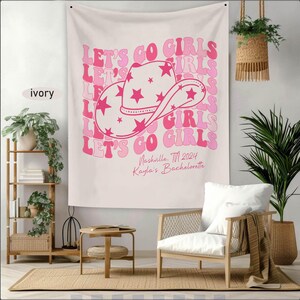 Puede incluir: Tapiz rosa y blanco con el texto "Let's Go Girls" repetido en una fuente retro. Un sombrero de vaquero rosa con estrellas blancas est&aacute; en el centro del tapiz. El texto "Nashville, TN 2024 Kayla's Bachelorette" est&aacute; en la parte inferior.