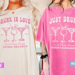 May include: Ivory and pink t-shirts with cocktail graphics. One shirt reads "DRUNK IN LOVE" with "West Palm Beach FUTURE MRS.SMITH 2024". The other is pink and says "JUST DRUNK" with "West Palm Beach LAUREN'S BACHELORETTE 2024".