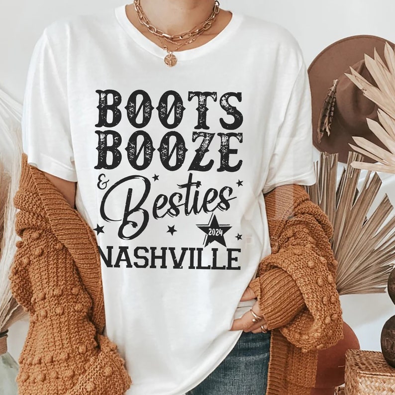 Może przedstawiać: Biała koszulka z napisem "Boots, Booze & Besties Nashville 2024" w czarnym kolorze. Koszulka ma okrągły dekolt i kr&oacute;tkie rękawy. Og&oacute;lny motyw to swobodny, zabawny styl.
