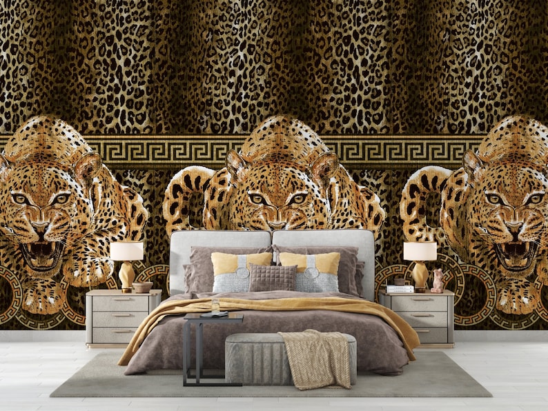 May include: A bedroom interior with a bed, two nightstands, and a leopard print wallpaper with a gold Greek key border. The wallpaper features three snarling leopards.