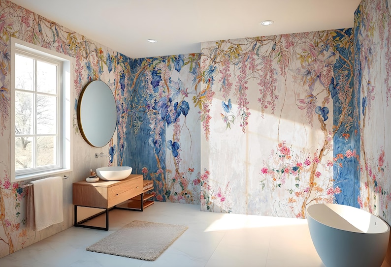 May include: A bathroom with floral wallpaper featuring pink, blue, and yellow flowers and vines. The room includes a wooden vanity with a round mirror, a white sink, and a freestanding bathtub. A window provides natural light.