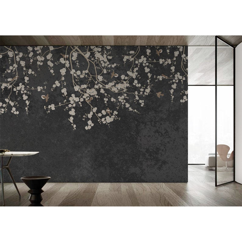 May include: A dark gray wall mural with a white floral design featuring delicate branches and small white flowers. The design is reminiscent of cherry blossoms and includes small brown birds throughout the branches.