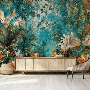 May include: A teal blue tropical jungle mural with a wooden cabinet and a wicker chair in front of it. The mural features lush green foliage, vibrant flowers, and birds.