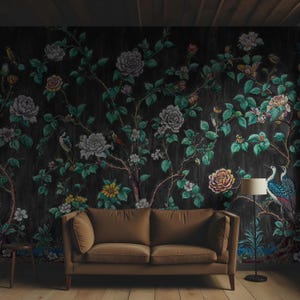 May include: Dark floral wallpaper with a botanical design of large, colourful flowers, birds, and foliage. A brown sofa and a floor lamp are in front of the wallpaper, creating a cosy living room setting.