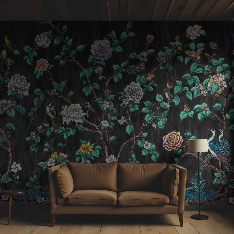 May include: Dark floral wallpaper with a botanical design of large, colourful flowers, birds, and foliage. A brown sofa and a floor lamp are in front of the wallpaper, creating a cosy living room setting.