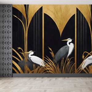 May include: A decorative wall mural featuring three herons in a stylized art deco design. The background is black with gold accents and vertical lines. The herons are depicted in shades of gray and white, with long beaks and elegant poses. The mural is a striking piece of wall art.