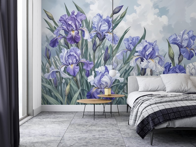 May include: A bedroom interior with a wall mural featuring a cluster of purple and white iris flowers against a blue sky background. The mural is framed by a white trim and a window with a dark curtain. A bed with a white headboard and a gray and white checkered blanket is in the foreground.