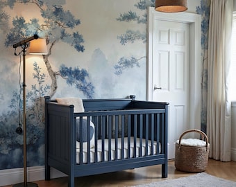 May include: A dark blue crib with white slatted sides and a white mattress. The crib is in a nursery with a blue and white wallpaper featuring a watercolor-style landscape. A wicker basket sits on the floor next to the crib.