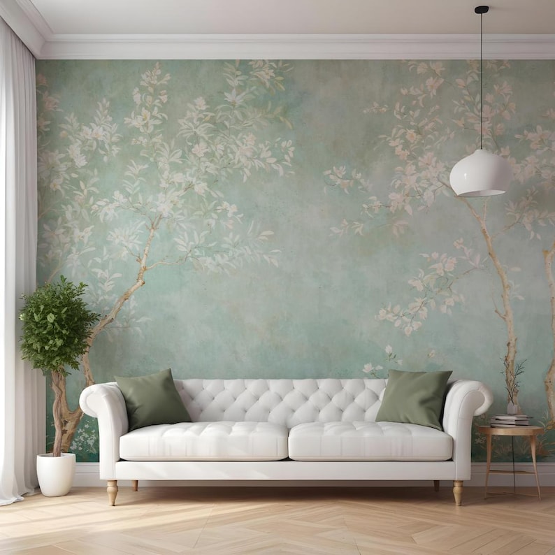 Puede incluir: Un sof&aacute; blanco con respaldo capiton&eacute; y cojines verdes se encuentra en una habitaci&oacute;n con papel tapiz floral verde claro.