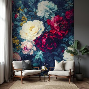 May include: A large floral wall mural featuring oversized blooms in shades of red, white, and pink against a dark blue background. Two armchairs with light-colored upholstery and wooden frames are in front of the mural. A small side table and a potted plant complete the scene.