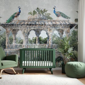 May include: A green cot and rocking chair in a nursery with a mural of a temple and peacocks. A green ottoman and potted plant are also in the room. The cot has a white mattress. The mural has a vintage, watercolour style.