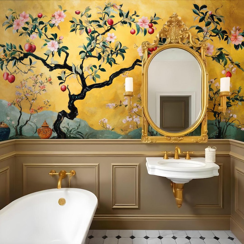 May include: A white porcelain bathroom sink with gold faucets and a white pedestal base. The sink is mounted on a wall with brown wainscoting and a gold-framed oval mirror above it. The wall behind the sink features a yellow and gold floral wallpaper with a black tree branch design.