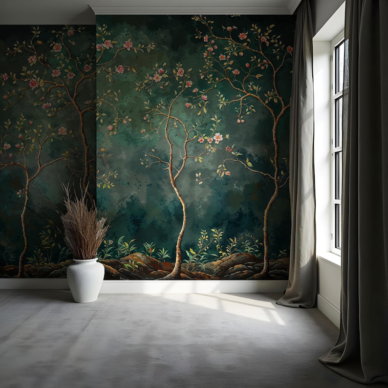 Op de afbeelding: Een kamer met een donkergroene muurschildering met gestileerde bomen en roze bloesems. Een witte vaas met gedroogde planten staat op een grijze vloer. Een raam met grijze gordijnen bevindt zich aan de rechterkant.