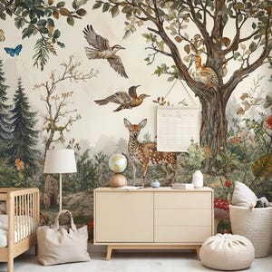 May include: A nursery room with a woodland mural featuring a deer, birds, and trees. The mural is on a wall behind a dresser, a crib, and a floor lamp. There is a woven basket with a red and white mushroom on the floor.