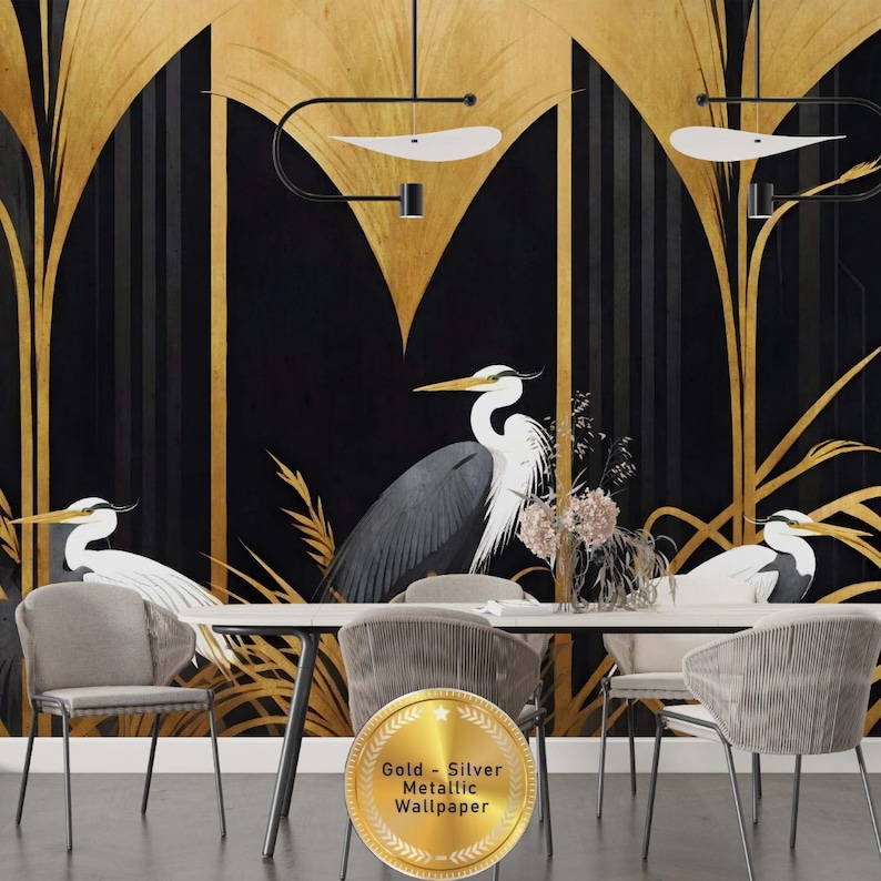 May include: A dining room scene featuring a black and gold metallic wallpaper with a heron design. The wallpaper has a stylized art deco design with gold accents. The room includes a white table, gray chairs, and decorative lighting.
