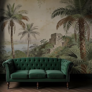 Puede incluir: Un sof&aacute; verde esmeralda con botones y patas de madera se encuentra frente a un mural que representa un paisaje tropical con palmeras, un lago y ruinas antiguas. La habitaci&oacute;n tiene un suelo de madera oscura.