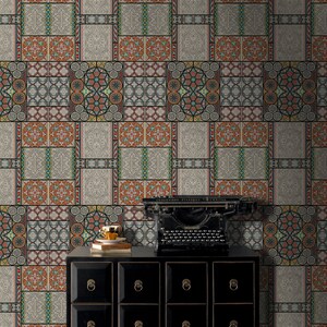 May include: A black dresser with six drawers and gold handles sits in front of a wall covered in patterned wallpaper. The wallpaper features a repeating design of colorful geometric shapes and patterns. A vintage typewriter sits on top of the dresser.