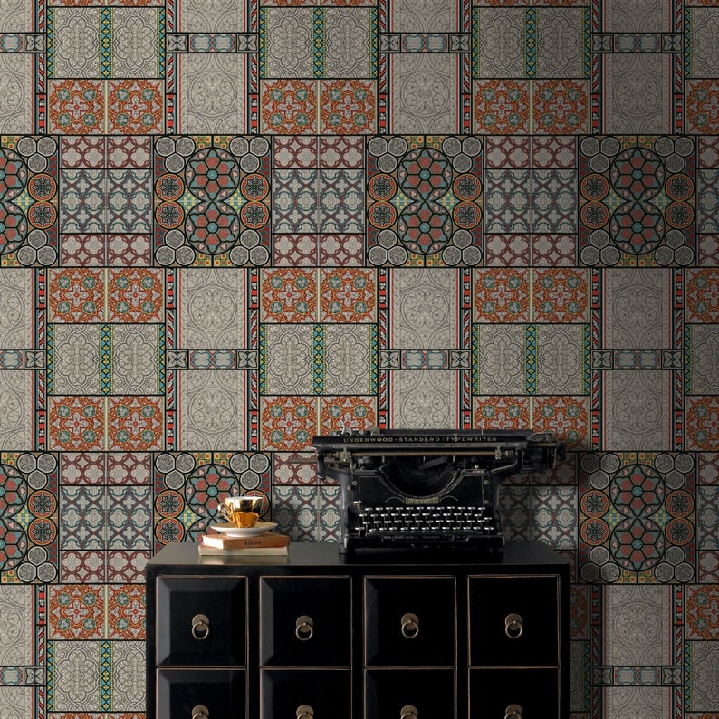 May include: A black dresser with six drawers and gold handles sits in front of a wall covered in patterned wallpaper. The wallpaper features a repeating design of colorful geometric shapes and patterns. A vintage typewriter sits on top of the dresser.