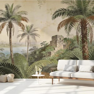 Puede incluir: Un mural de estilo vintage que representa un paisaje tropical con palmeras, exuberante follaje verde y una estructura de piedra. Un sof&aacute; blanco con cojines se encuentra frente al mural. La escena evoca una sensaci&oacute;n de tranquilidad y belleza natural.