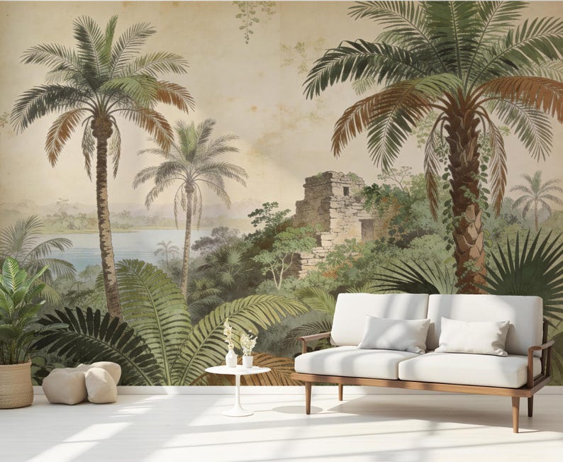 Puede incluir: Un mural de estilo vintage que representa un paisaje tropical con palmeras, exuberante follaje verde y una estructura de piedra. Un sof&aacute; blanco con cojines se encuentra frente al mural. La escena evoca una sensaci&oacute;n de tranquilidad y belleza natural.