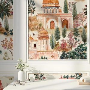 K&ouml;nnte beinhalten: Ein Aquarellbild eines rosa und wei&szlig;en Geb&auml;udes mit goldenen Kuppeln und B&ouml;gen. Das Geb&auml;ude ist von B&auml;umen und Blumen umgeben. Das Bild ist gerahmt und h&auml;ngt an einer wei&szlig;en Wand.