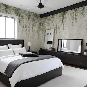 May include: A modern bedroom with a black bed frame, white bedding, and a gray throw blanket. The room features a large mirror, dark wood dressers, and a nature-themed wallpaper with hanging green leaves. A white rug covers the floor.