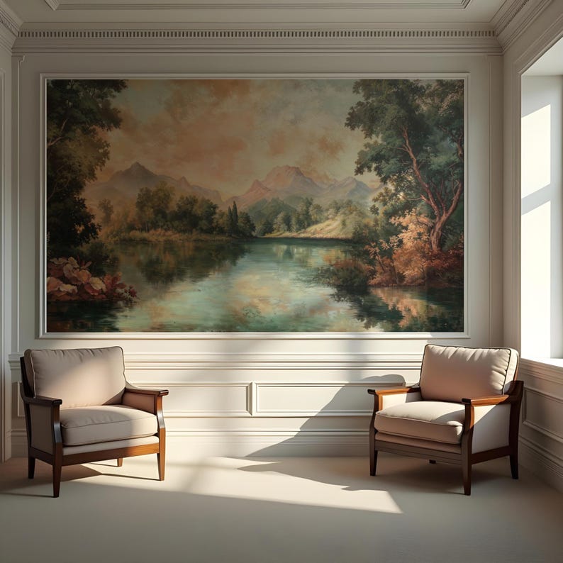 May include: Two beige armchairs with wooden frames sit in a room with white walls and a large painting of a lake and mountains on the wall.
