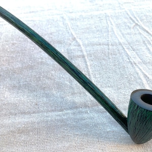 May include: A long, green wooden smoking pipe with a curved stem and a bowl with a small hole in the top.