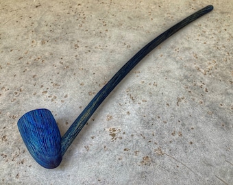 May include: A long, blue wooden smoking pipe with a curved bowl. The pipe is made of a dark wood with a blue stain.