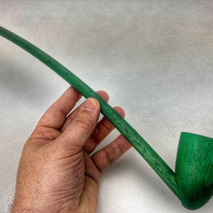 May include: A long, green wooden smoking pipe with a curved stem and a round bowl.