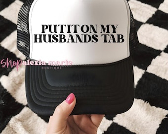 Put It On My Husbands Tab Trucker Hat