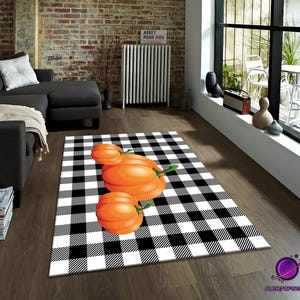 May include: A rectangular rug with a black and white chequered pattern. The rug features three orange pumpkins with green stems. The rug is placed on a wooden floor in a living room setting.