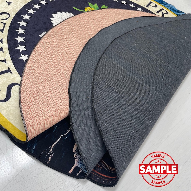 May include: A layered view of several circular rugs, showcasing their varied designs and textures. One rug displays a navy blue pattern with white stars and text, while another has a pinkish-brown textured surface. The bottom rug features a black and white marble design.