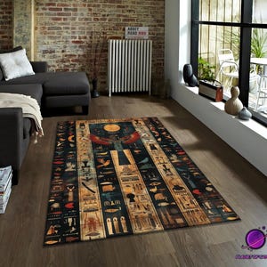 Puede incluir: Alfombra rectangular con temática egipcia. La alfombra presenta un fondo oscuro con jeroglíficos, un gran sol y una figura alada en tonos rojos, dorados y azules. La alfombra está colocada sobre un suelo de madera.