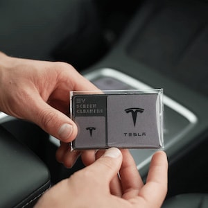 May include: A grey package containing two microfiber cloths for cleaning EV screens. The package has the Tesla logo and the text "EV Screen Cleaners" and "Tesla".