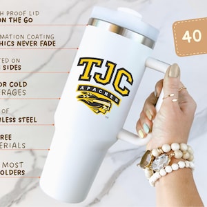 May include: White 40 oz tumbler with a handle, featuring the text "TJC APACHES" in black and yellow. The tumbler has a splash-proof lid and is made of stainless steel. The text on the tumbler says "Graphics never fade" and "Hot or cold beverages".