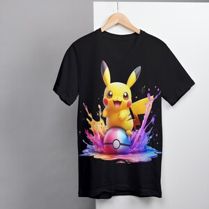 May include: Black V-neck t-shirt with a colorful graphic of Pikachu sitting on a Pokeball surrounded by colorful paint splatters.