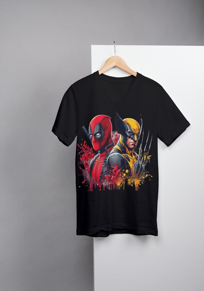 May include: Black V-neck t-shirt with a graphic print of Deadpool and Wolverine in a splash of red and yellow paint.