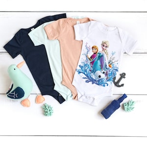 Pu&ograve; includere: Quattro body per neonati, uno con sfondo bianco e una grafica colorata di Elsa e Anna di Frozen, uno azzurro, uno pesca e uno blu scuro.