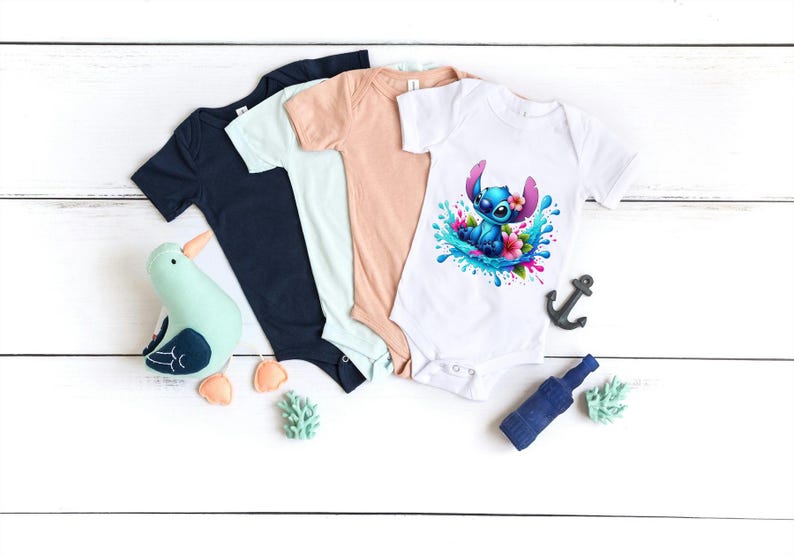 May include: Three baby onesies in different colors: navy blue, light blue, and peach. The white onesie has a colorful graphic of Stitch from Lilo & Stitch surfing on a wave with flowers.