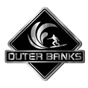 Puede incluir: Un logotipo negro y plateado que presenta a un surfista surfeando una ola. El logotipo tiene forma de diamante con un borde plateado y las palabras "OUTER BANKS" en un rectángulo plateado debajo.